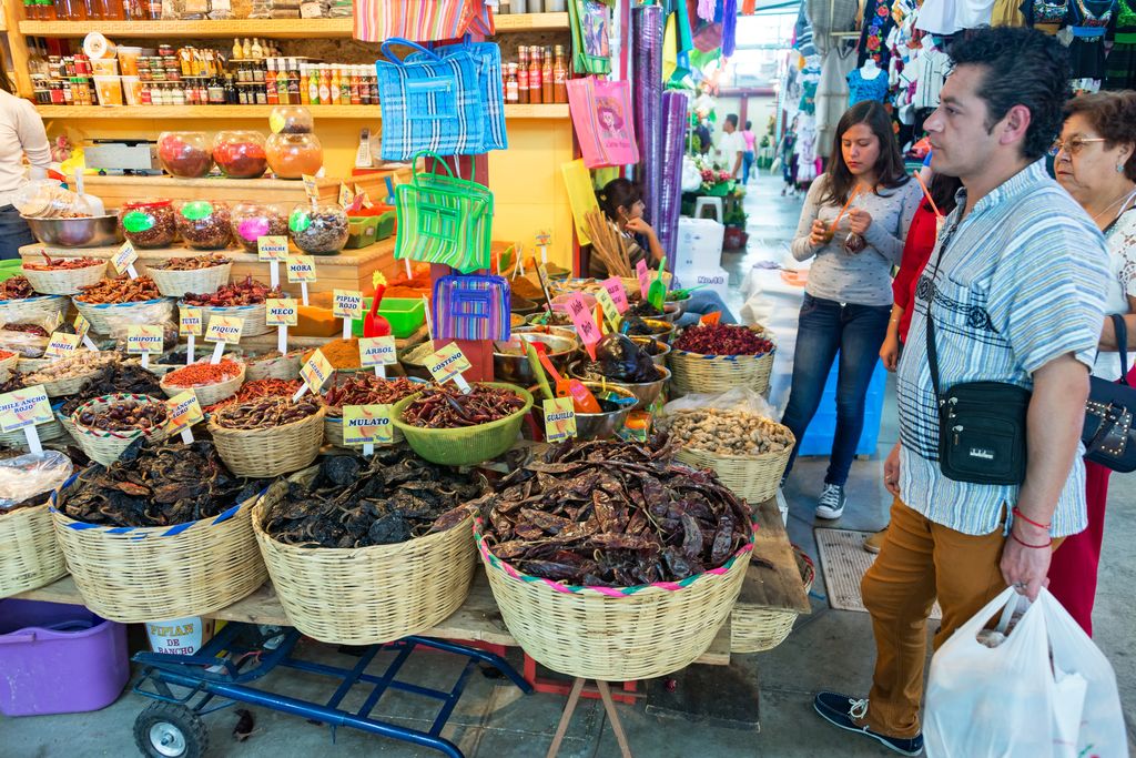 A man and two women shopping in a market in Mexico